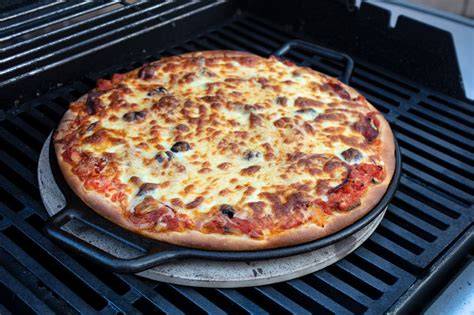 Pizza op pizzasteen in barbecue